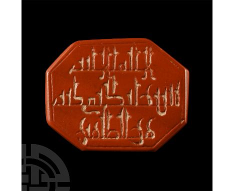 20th century A.D.. Octagonal form bearing Kufic script over three lines to one face; possibly red jade or jasper.  4.29 grams