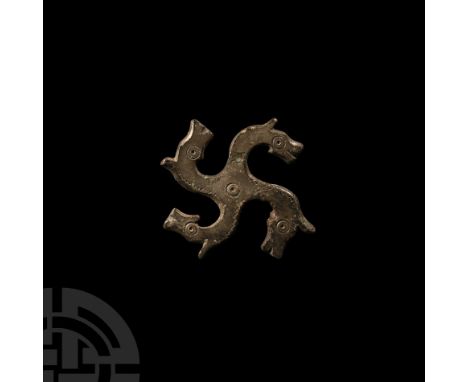 3rd-4th century A.D.. Swastika-shaped fibula with horse-head decoration, each head with punched ring-and-dot eye, a similar m