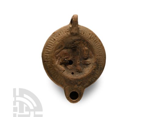 2nd-3rd century A.D.. Loop handle to the rear, low discus with an advancing lion with its head turned to the right, hatched d