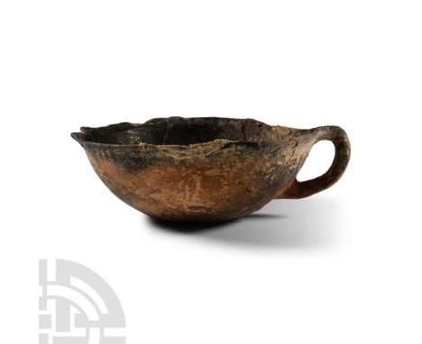 Middle Bronze Age, circa 2000-1650 B.C. Of reserved slip ware, comprising a shallow bowl with indented base, single loop hand