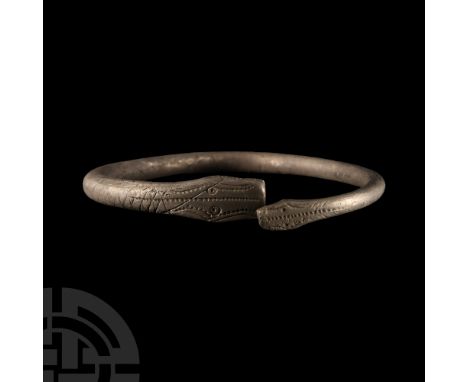 1st century B.C.-1st century A.D.. Tapering round-section bar with incised serpent-head detailing to both ends.  65 grams, 83