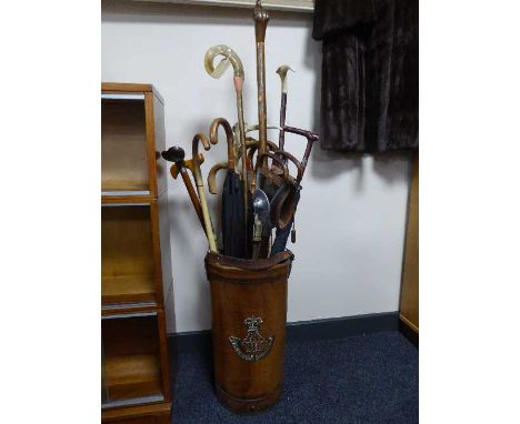 A leather stick stand bearing Durham Light Infantry emblem, together with a collection of good quality walking sticks and umb