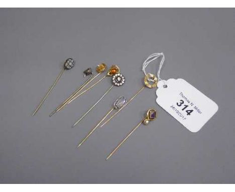 A collection of eight lapel pins, examples of 14k and platinum moonstone, paste, micro mosaic, amethyst and seed pearl, amber