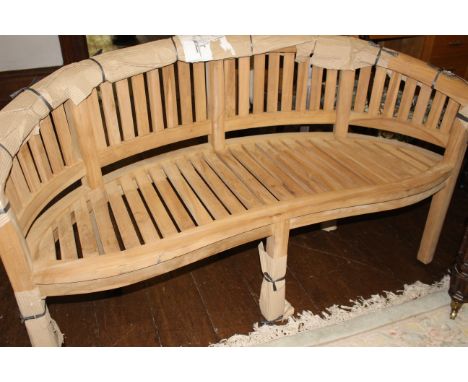 A "banana" garden bench with curved slatted back and seat, on square legs, 88cm high x 158cm wide x 55 deep 