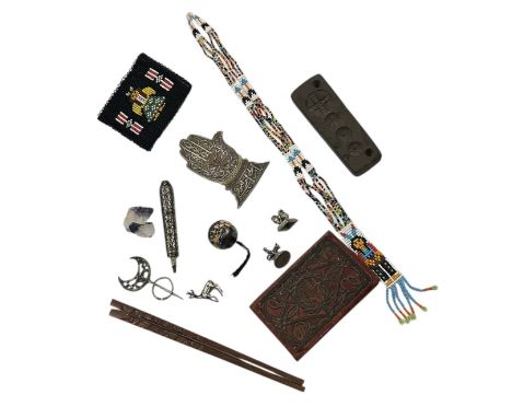 A group of ethnic items to include a brass hand of Fatima, a parasol handle in unmarked white metal, Japanese carved wood hai