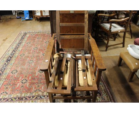 Antique oak reclining chair with leg extensions, this item will need repair and refurbishment.
