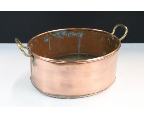 Copper oval planter with rolled rim and twin brass loop handles, 31cm wide