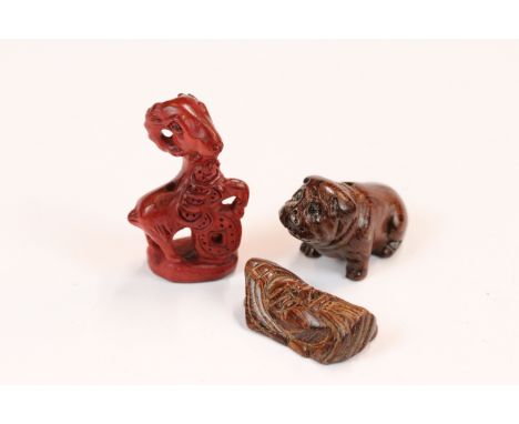 Three miniature wood netsuke figures to include bulldog, money goat and face of a wise old man
