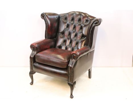 Oxblood leather chesterfield wing back arm chair having button back seat with cabriole legs. Measures 94 x 75 x 90cm 