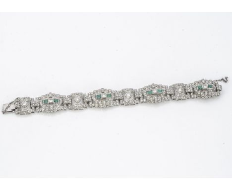An emerald and diamond white metal bracelet, of architectural open form, set with rectangular cut emeralds and brilliant and 