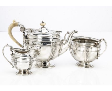 An Edwardian silver three piece tea set by James Dixon &amp; Sons, oval footed forms with raised designs, the teapot with ivo