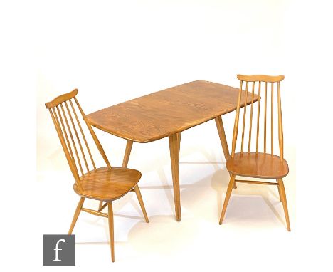 An Ercol light elm and beech table and chairs to include a set of four model 369 Goldsmith Windsor chairs and a model 383 dro