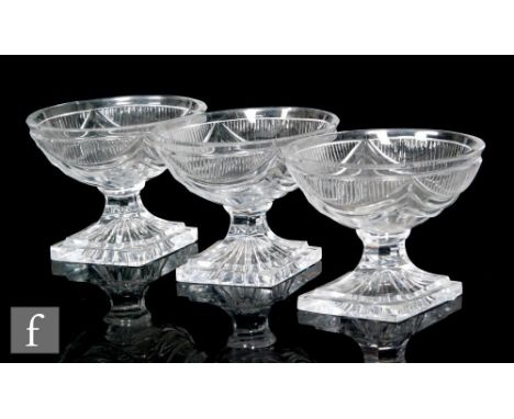 A set of three Georgian glass pedestal salts, each with an oval bowl cut with swags, and raised to a diamond form lemon squee