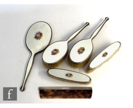 A hallmarked silver and enamel decorated five piece hair brush set comprising a hand mirror and four brushes each decorated w