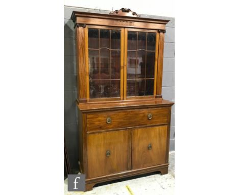 A late 19th to early 20th Century mahogany secretaire bookcase enclosed by a pair of bar glazed doors below a dentil fluted c