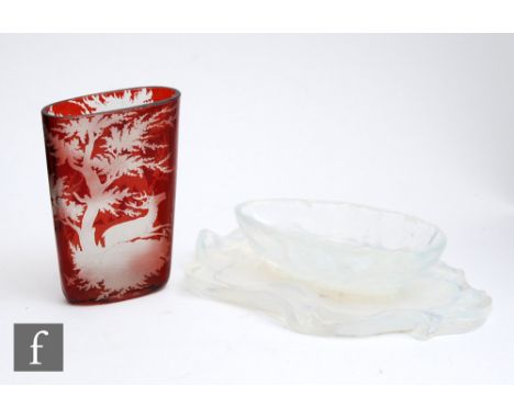 An early 20th Century Bohemian glass vase of compressed form, cased in ruby over clear and engraved with deer in a wooded lan