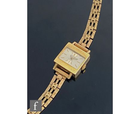 A lady's 9ct hallmarked Excalibur wrist watch, batons to a rectangular silvered dial, case and three bar gate bracelet, total