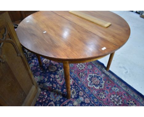 A vintage teak dining table of circular form diameter approx. 116cm, with additional extending leaf to centre