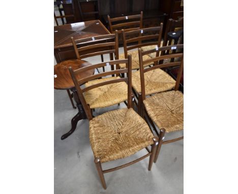 A set of five vintage teak dining chairs having rail backs and rush seats