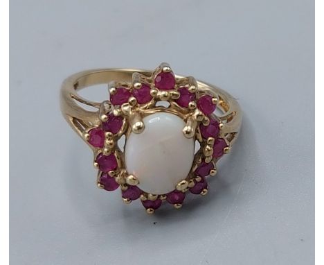 A 9ct gold opal and ruby set ring, with a cabachon opal surrounded by rubies, 3.1gms, ring size M 