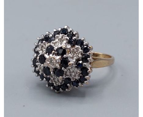 A 9ct gold diamond and sapphire cluster ring of tiered form, 4.9gms, ring size K 
