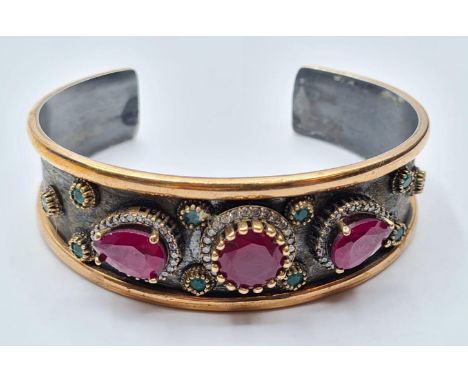 Antique gilded silver bangle with inset ruby's and other stones, weight 34g 