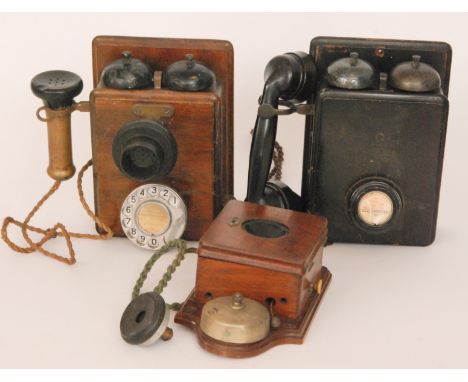 A twin bell walnut cased wall mounted telephone, height 24cm, an ebonised wall mounted set and a small mounted telephone with