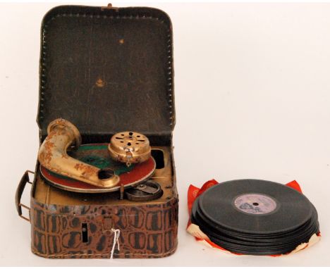 A late 1930s clockwork portable child's gramophone, playing eleven 15cm records and six 13.5cm records in a simulated crocodi