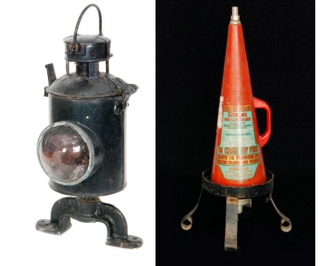 A black painted railway level crossing lamp with hinged lid above a bullseye lens together with a Minimax witches hat type re