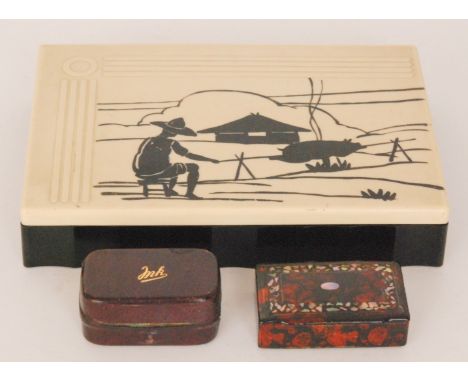 A 1930s cream Bakelite rectangular cigarette box, the cover detailed with a scout roasting a pig over an open fire, width 21.