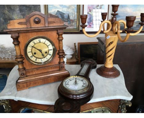 An oak cased mantel clock, oak barometer and two tone stained wooden candelabra. (3)