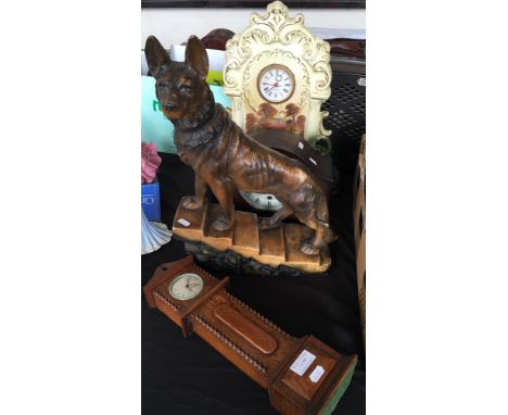 A lot to include pottery mantel clock, miniature long case clock and another together with a figure of an alsation. (4)
