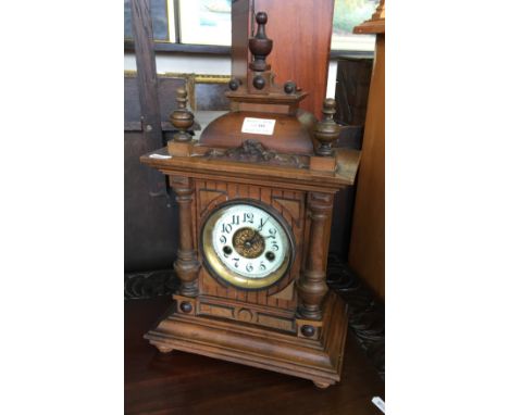 An early 20th Century oak cased mantel clock with turned finials to top.