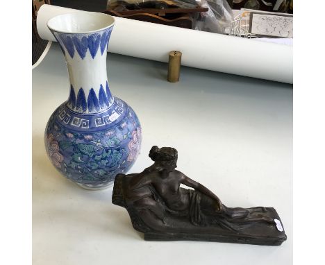 A bronzed model of a reclining nude together with an oriental vase.