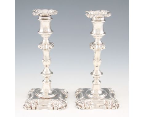 A pair of William IV silver weighted candlesticks, the knopped stems and square bases decorated with scroll design, with remo