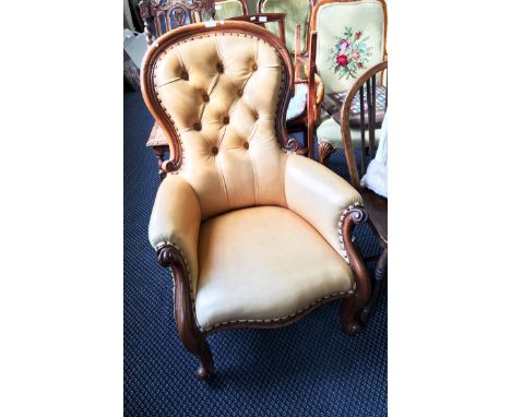 A Victorian mahogany arm chair with button backed cream leather upholstery.