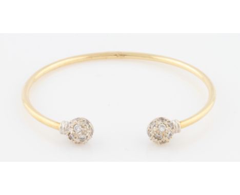 SOLD WITHOUT BUYERS PREMIUM AND VAT. A 9ct yellow gold torque bangle, ends pave set with round cut colourless stones, hallmar