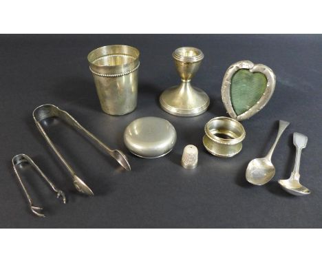 A small group of silver items, comprising a dwarf candlestick, 7 by 7.5cm high, a heart shaped easel photo frame, 7cm, small 