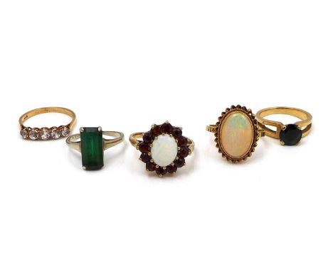 A group of five gold rings, comprising a 9ct yellow gold opal and garnet flowerhead ring, the 10 by 8mm oval surrounded by tw