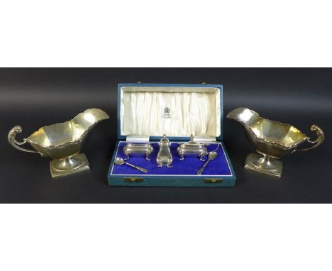 A pair of Edwardian silver sauce boats, the handles with cast jaguar heads, and scroll rim, raised on a curved rectangular ba