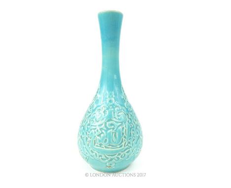 A 20th century, Persian ceramic vase with turquoise glaze, elongated neck and the bulbous body of the vase incised with Farsi