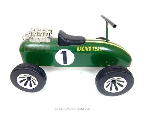 A vintage style child's ride-on car, in the style of a classic British racing car in racing green, marked 'Racing Team 1', wi