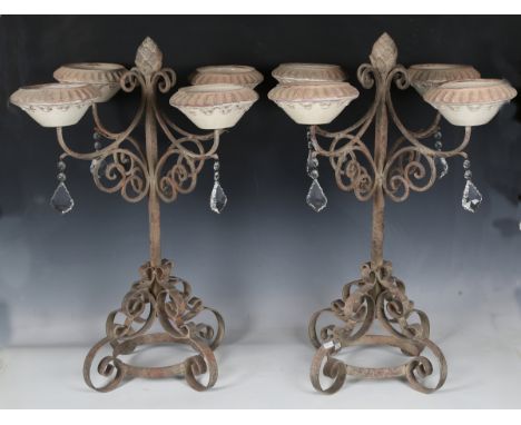A pair of modern painted wrought iron four-light candelabra with glazed pottery sconces and cut glass drops, height 68cm.Buye