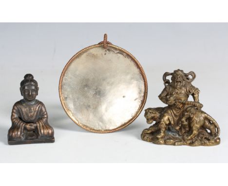 A Tibetan polished nickel pendant mirror, diameter 10cm, an Eastern cast bronze model of a warrior sitting upon a tiger, leng