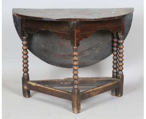 A Charles II oak circular single drop-flap credence style side table, raised on bobbin turned and block legs, height 75cm, di