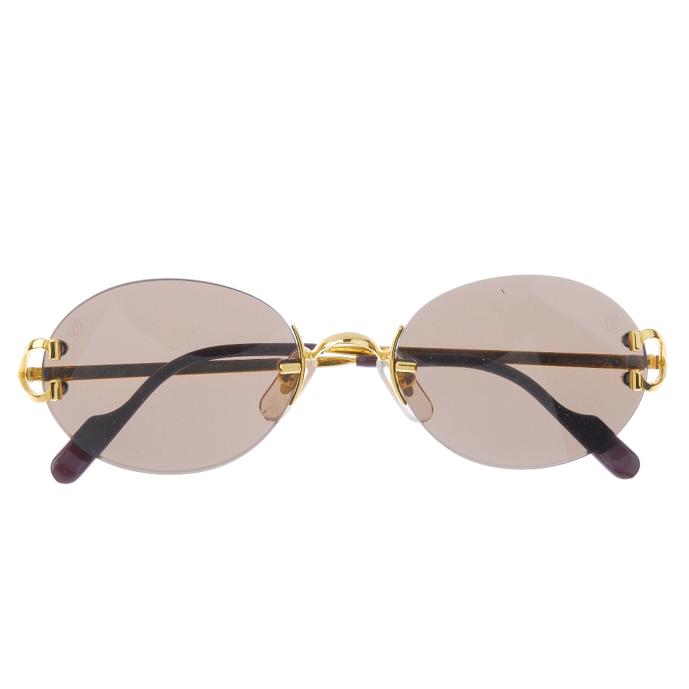 CARTIER - a pair of rimless sunglasses. Featuring oval shaped brown ...