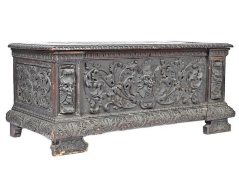 A large 19th century continental carved oak cassone chest / trunk being heavily carved with figural masks and relief work. Re