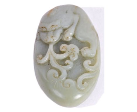 A 19th Century Chinese antique hand carved jade toggle having carving depicting a dragon among flames and scrolls. Ovoid form