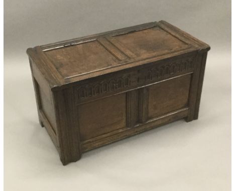 An 18th century oak two panelled coffer
The panelled hinged rectangular top above the carved frieze and twin panelled front, 