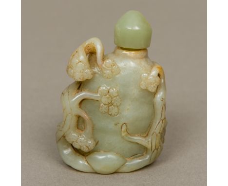 A Chinese carved green and russet jade snuff bottle
Decorated with flowering branches.  7.75 cm high.  CONDITION REPORTS: Sto